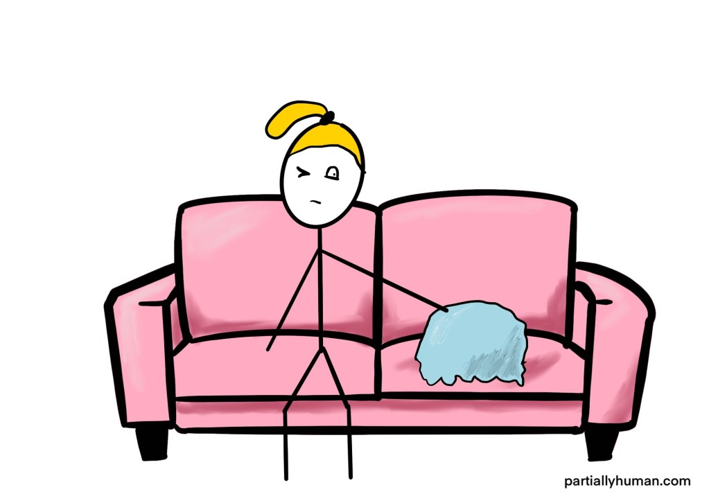 Girl sitting on couch, peeking out of one eye at lump next to her